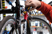 a cyclist examining a used bike up close while shopping