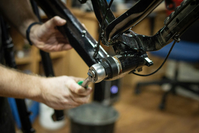 Cyclist inspecting used bike frame before buying second-hand bike