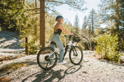 Women’s electric bike on a woodland trail — step-through e-bike ideal for commuting and weekend rides