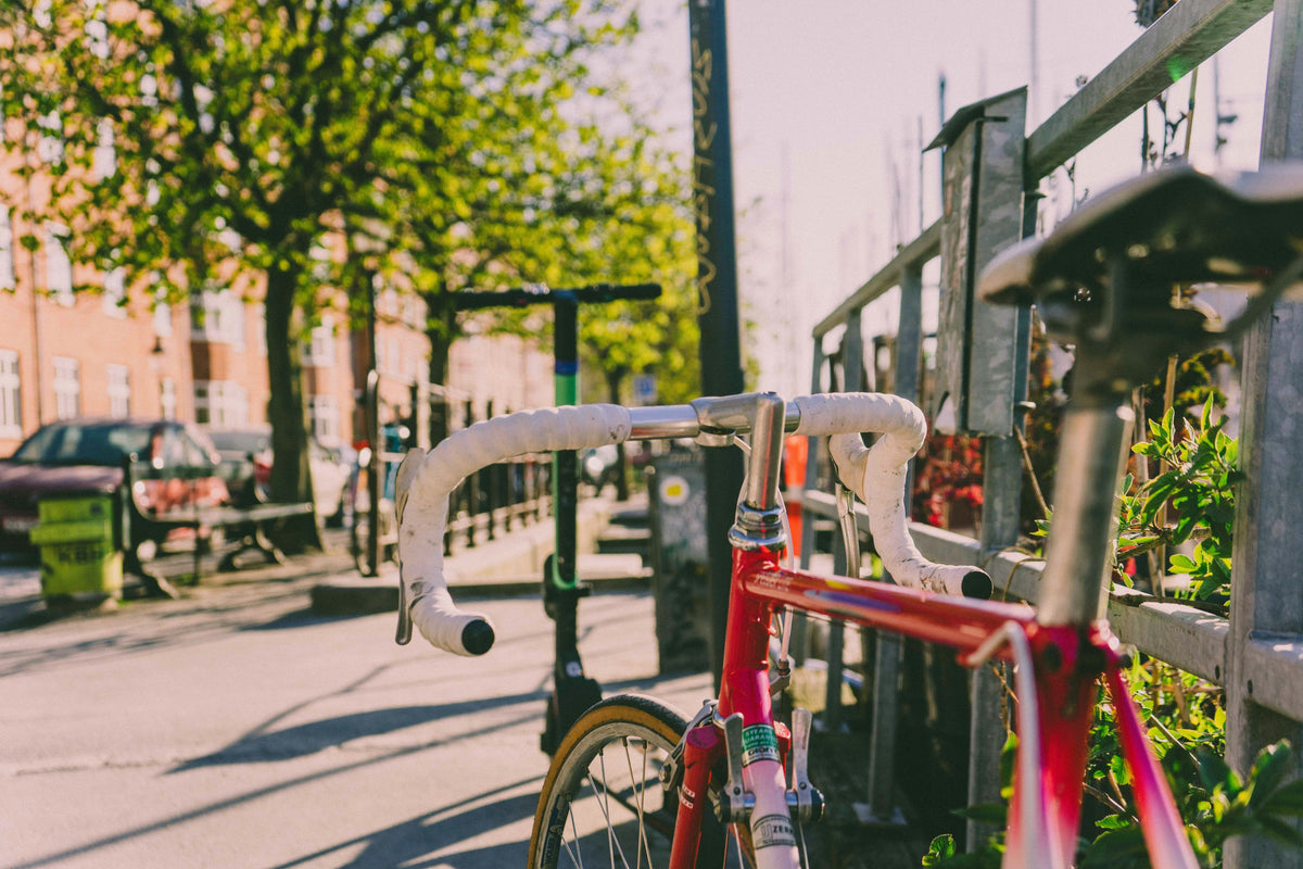 Premium red road bike in spring sunshine on a UK city street, perfect time to buy or upgrade your bike