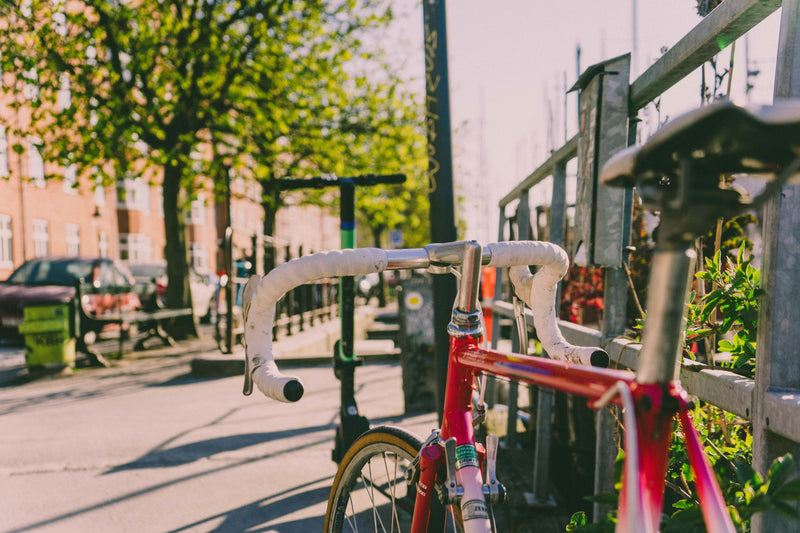 Premium red road bike in spring sunshine on a UK city street, perfect time to buy or upgrade your bike
