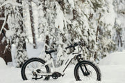 Himiway fat-tyre electric mountain bike standing in a snow-covered forest, showcasing off-road winter riding capabilities -- sell without the stress at MyNextBike.co.uk. 