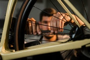 a cyclist closely inspecting a high-end used bike frame before buying