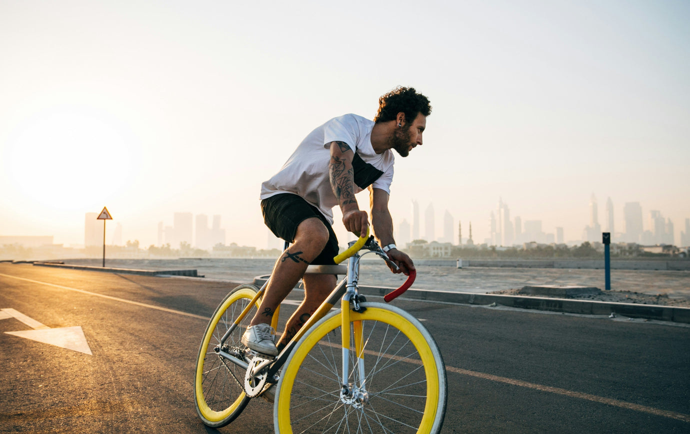 Cyclist riding a bike on a sunny road near water – buy used bikes safely online with MyNextBike.co.uk.