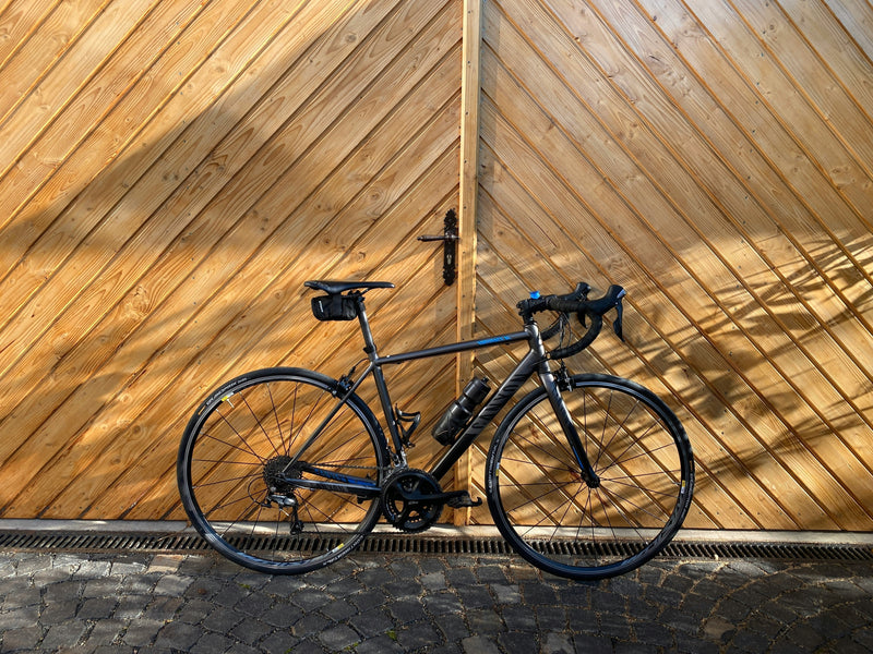 Modern road bike against a wooden backdrop in an urban setting, representing cycling lifestyle, road cycling, bike ownership, and premium performance bicycles