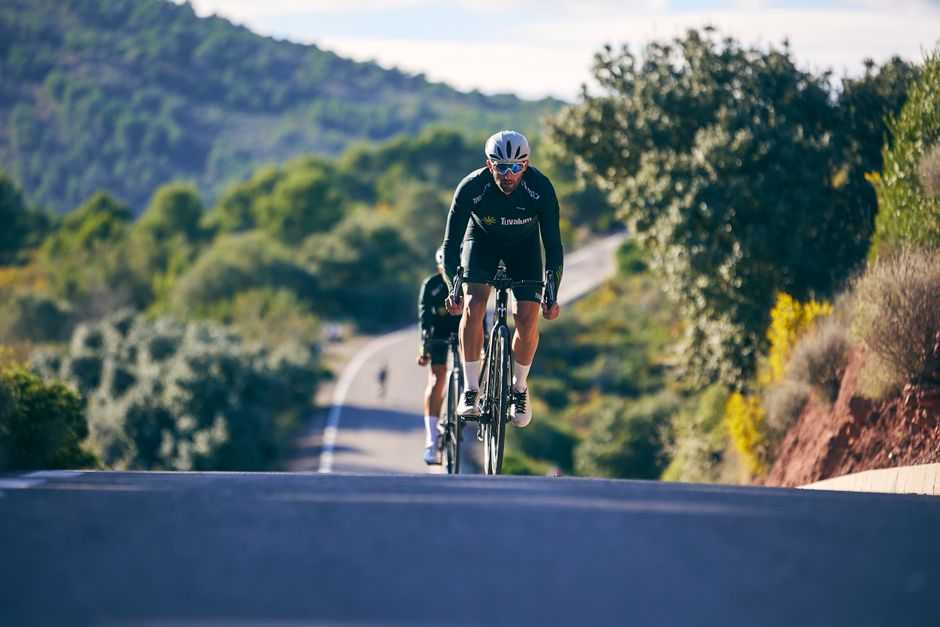 Cyclist training on a rural uphill road, capturing the essence of outdoor sports and countryside scenery.